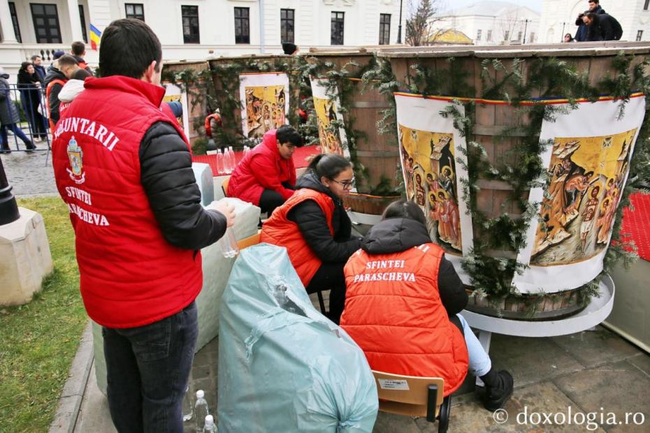 Voluntarii Sfintei Parascheva au oferit credincioșilor care au stat la rând sticle cu Aghiasmă Mare / Foto: Flavius Popa